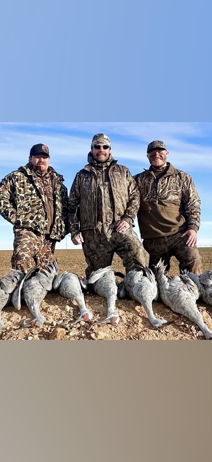 Three hunters together after a successful day in the field