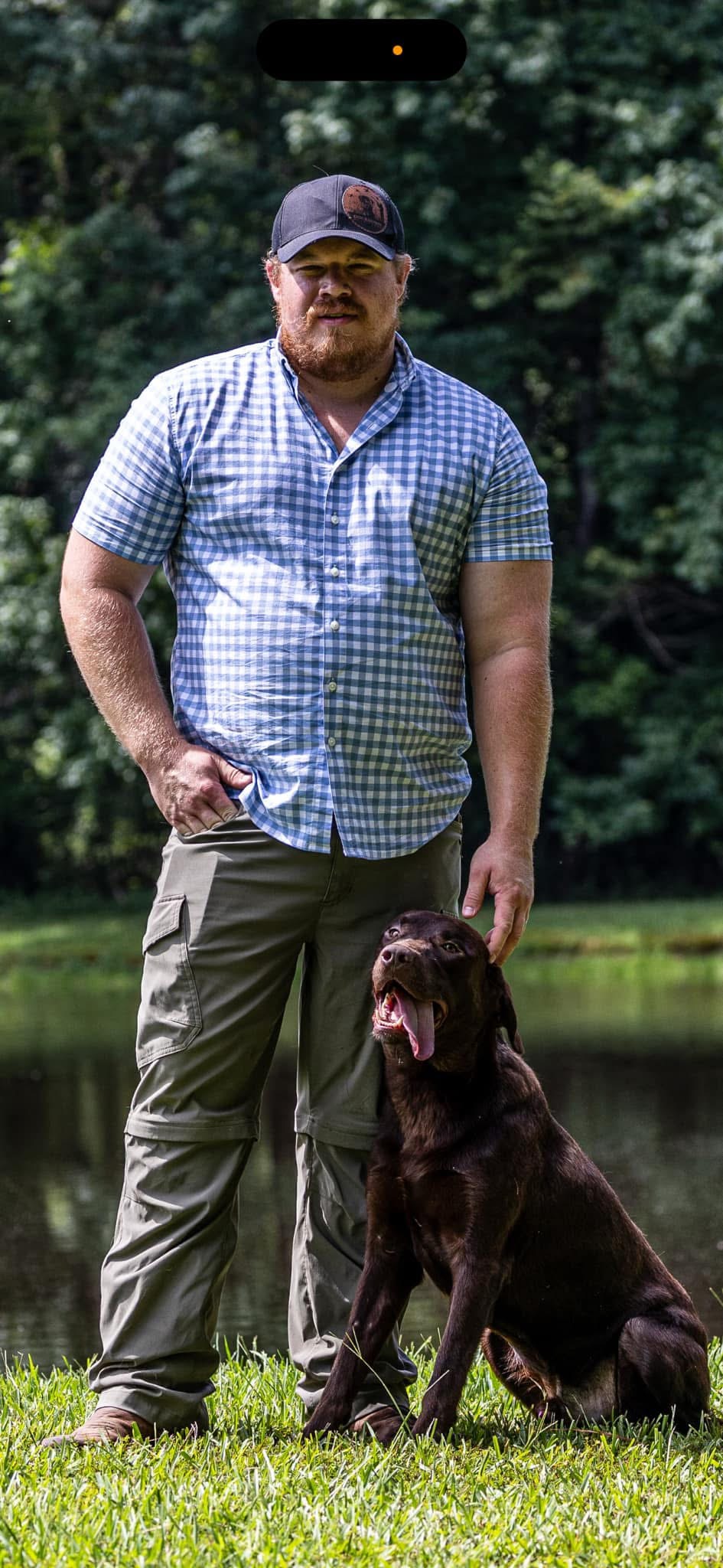 A hunter standing with a trained bird dog