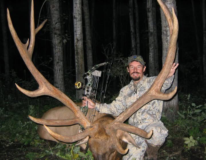 A hunter with a large whitetail in the woods
