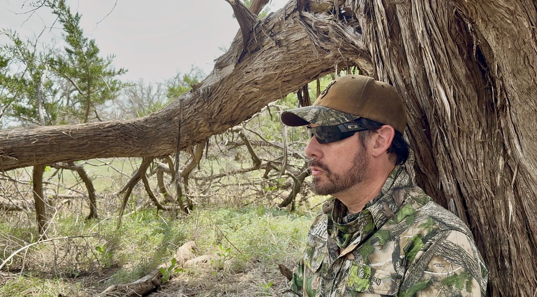 A hunter in camouflage pausing beneath a tree during a Pope Brothers hunt