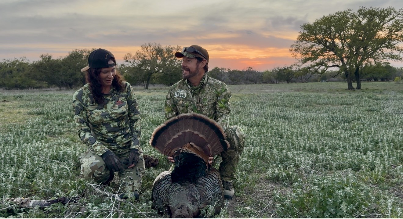 Two hunters with a turkey at sunset during a Pope Brothers hunt